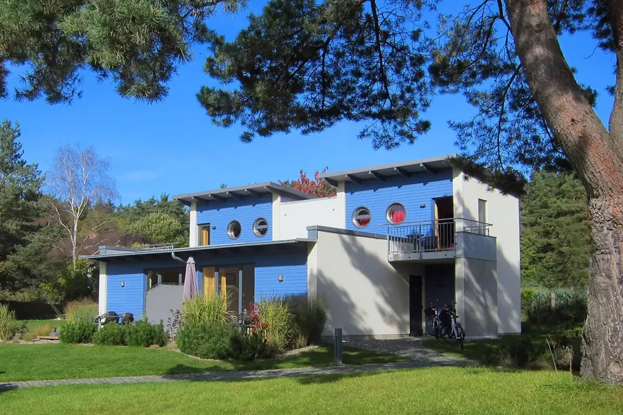 Haus Müritz mit blauer Holzfassade zwischen Kiefern