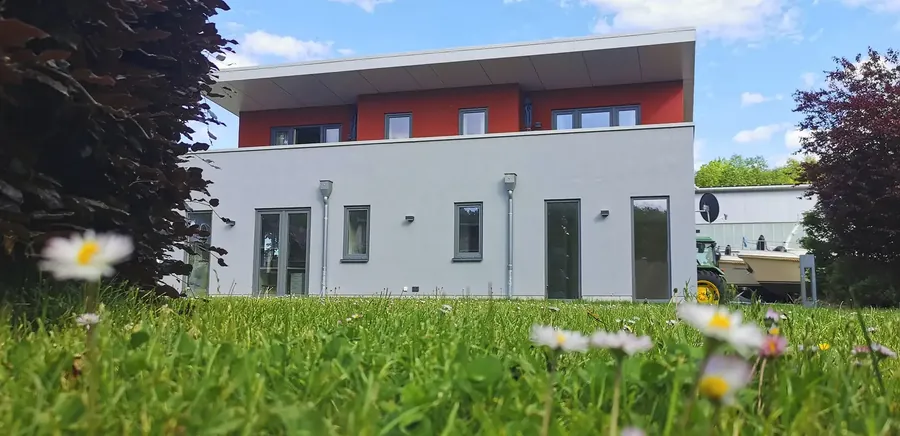 Haus Reecksee hinter einer Blumenwiese